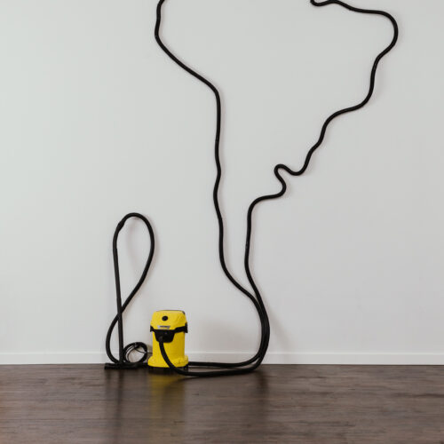 Alberto Borea, Latinoamerica - Vacuum Cleaner, 2017 Vacuum cleaner and extension hose on the wall. 224.4 x 102.4 x 21.7 in /570 x 260 x 55 cm
